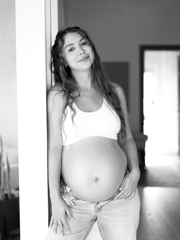 Expecting mother leaning in a doorway at home