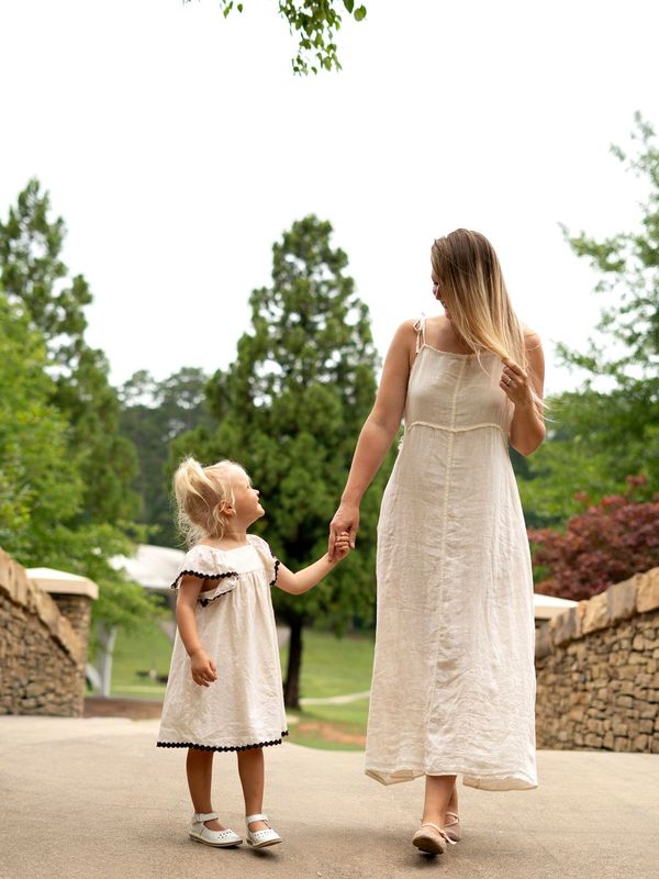 Mother and daughter walking hand in hand in the park