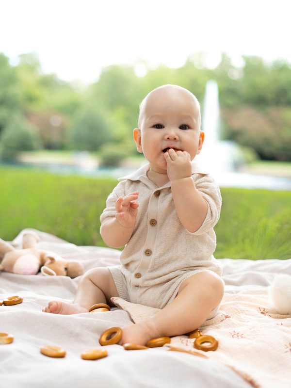 Baby sitting on a picnic blanket by the fountain