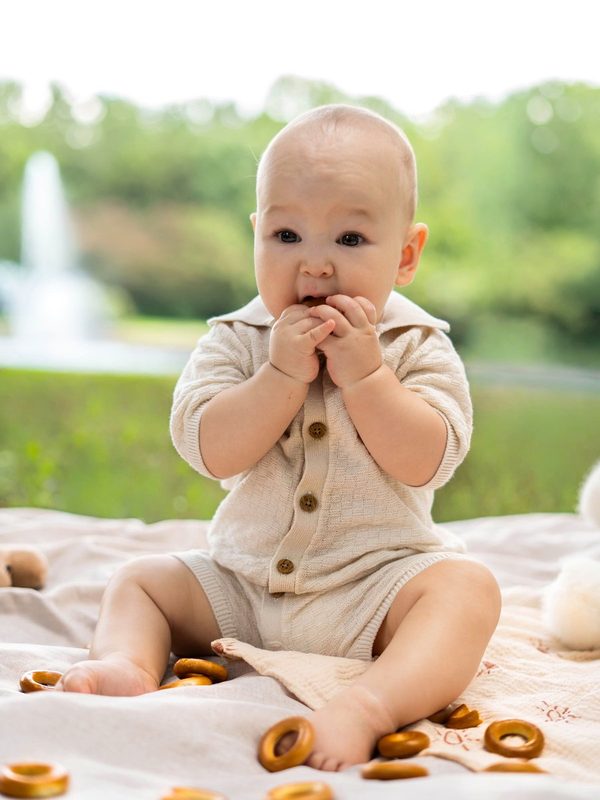 Baby sitting up on a picnic blanket