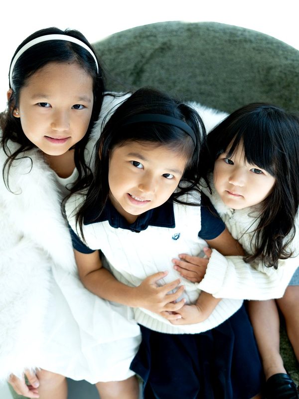 Three sisters leaning in for a portrait from above